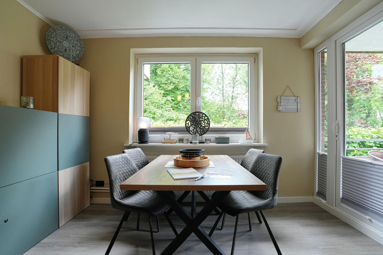 Esszimmer mit Tisch, Stühlen und Blick auf Garten