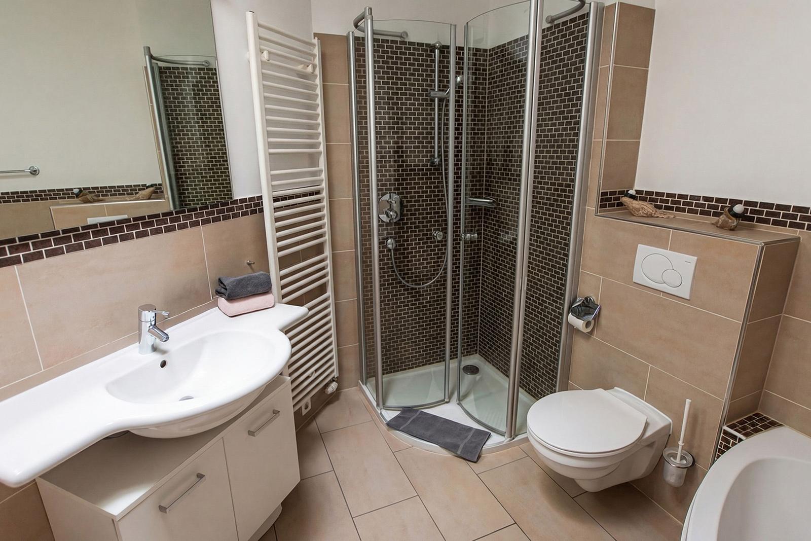 Badezimmer mit Dusche, Waschbecken und Toilette.