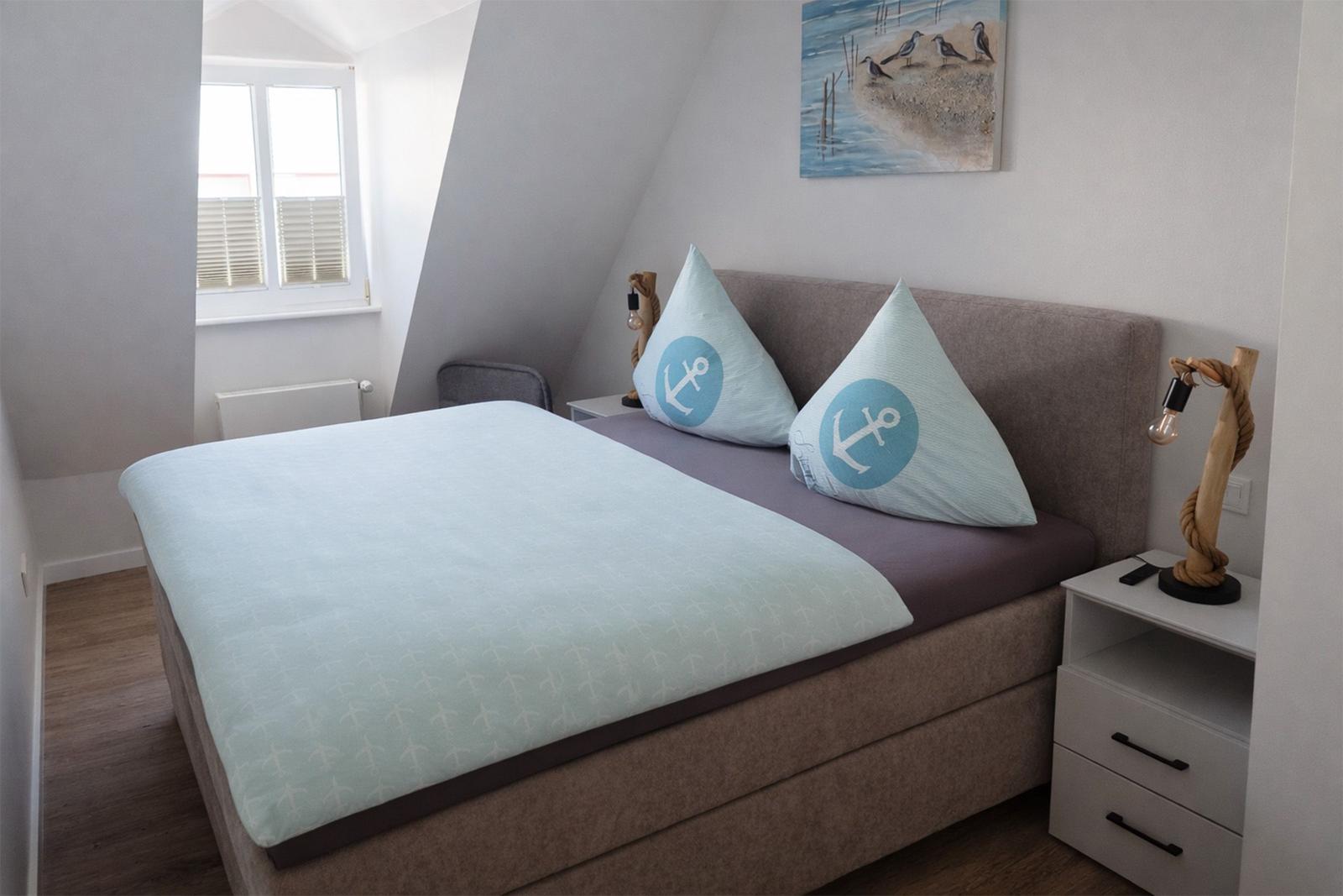 Schlafzimmer mit Doppelbett, Nachttisch und Wandbild