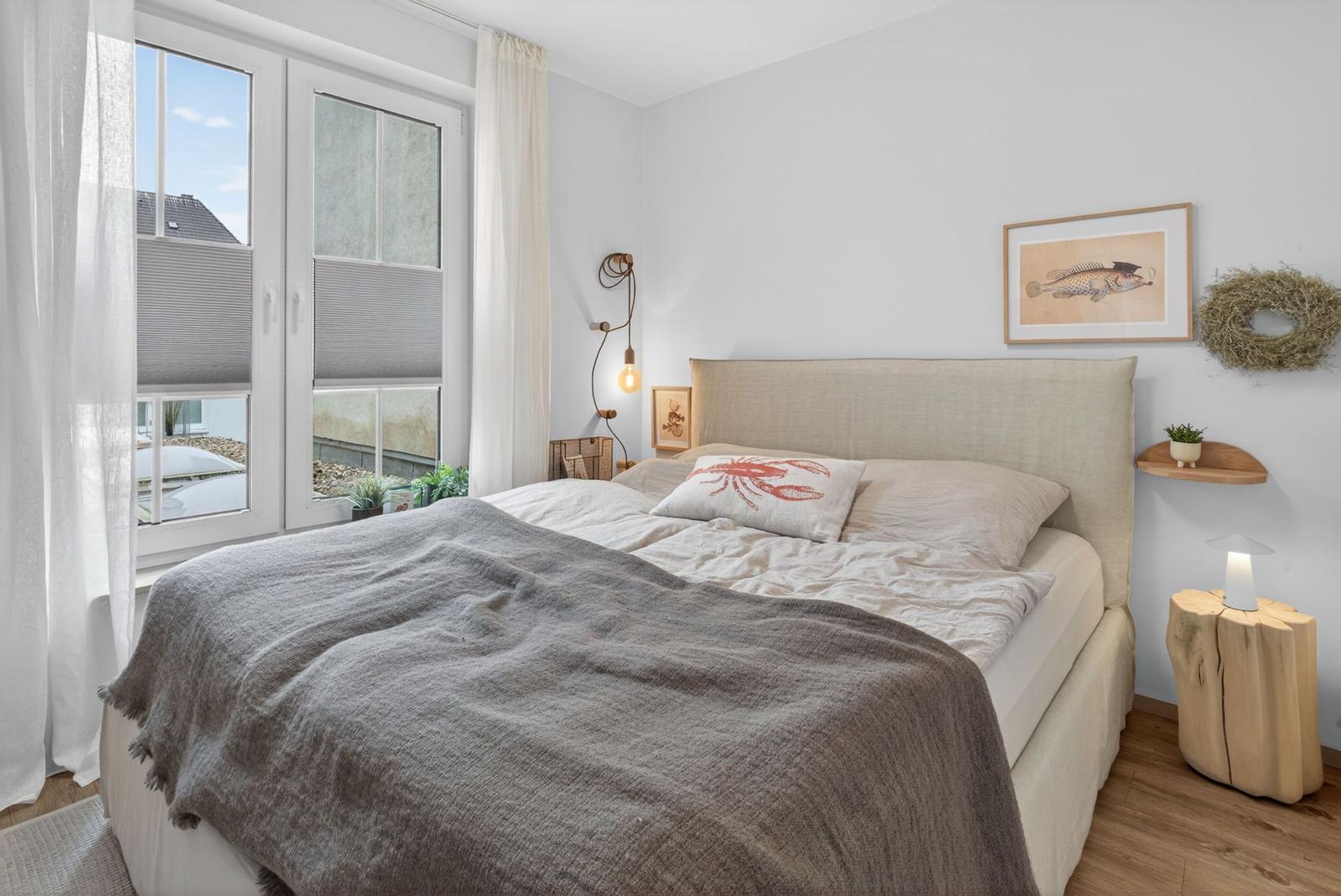 Ein Schlafzimmer mit Bett, Fenster und Wanddekoration.
