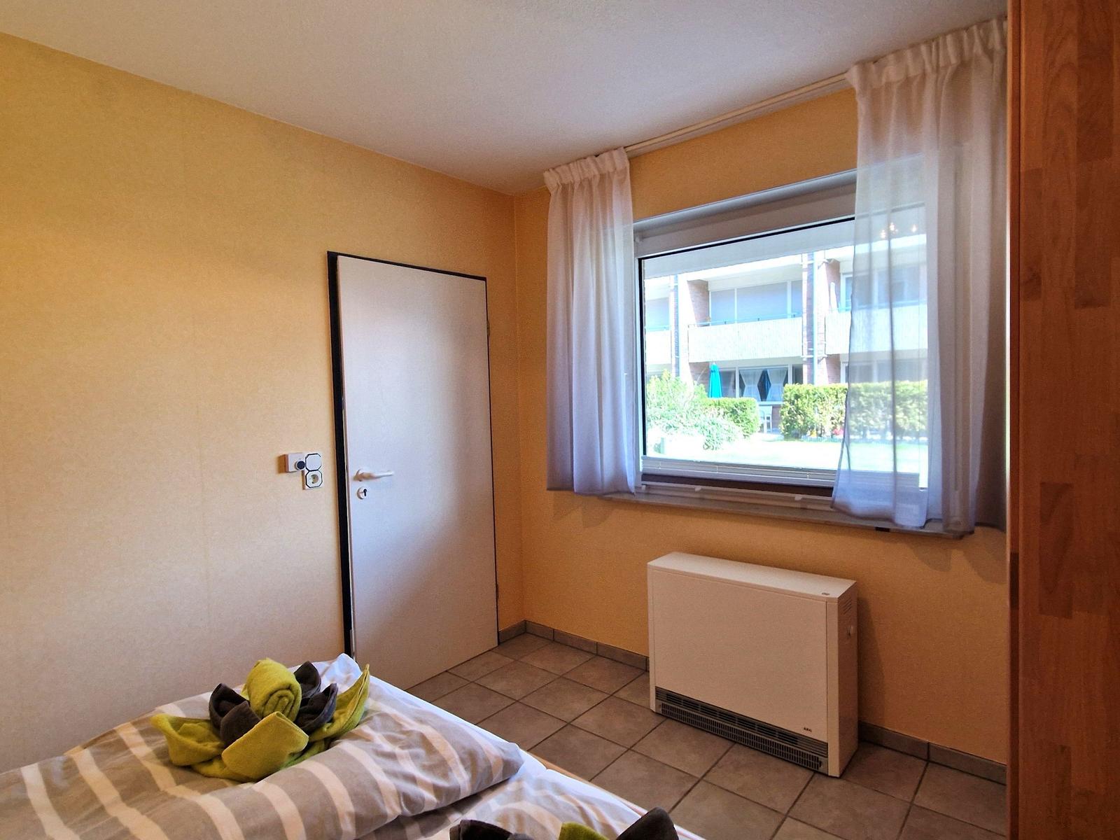 Schlafzimmer mit Bett, Fenster und Heizkörper