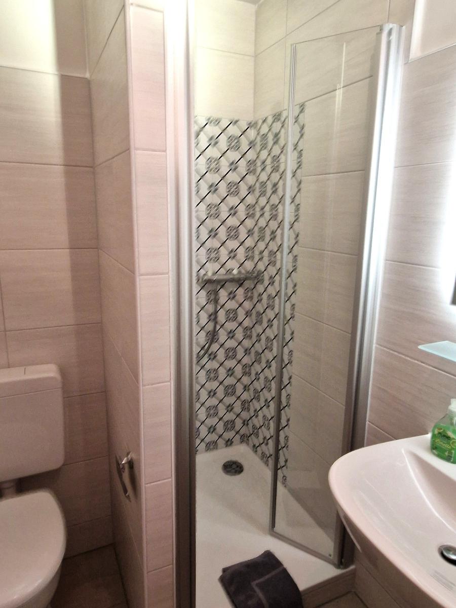 Badezimmer mit Dusche, Toilette und Waschbecken.