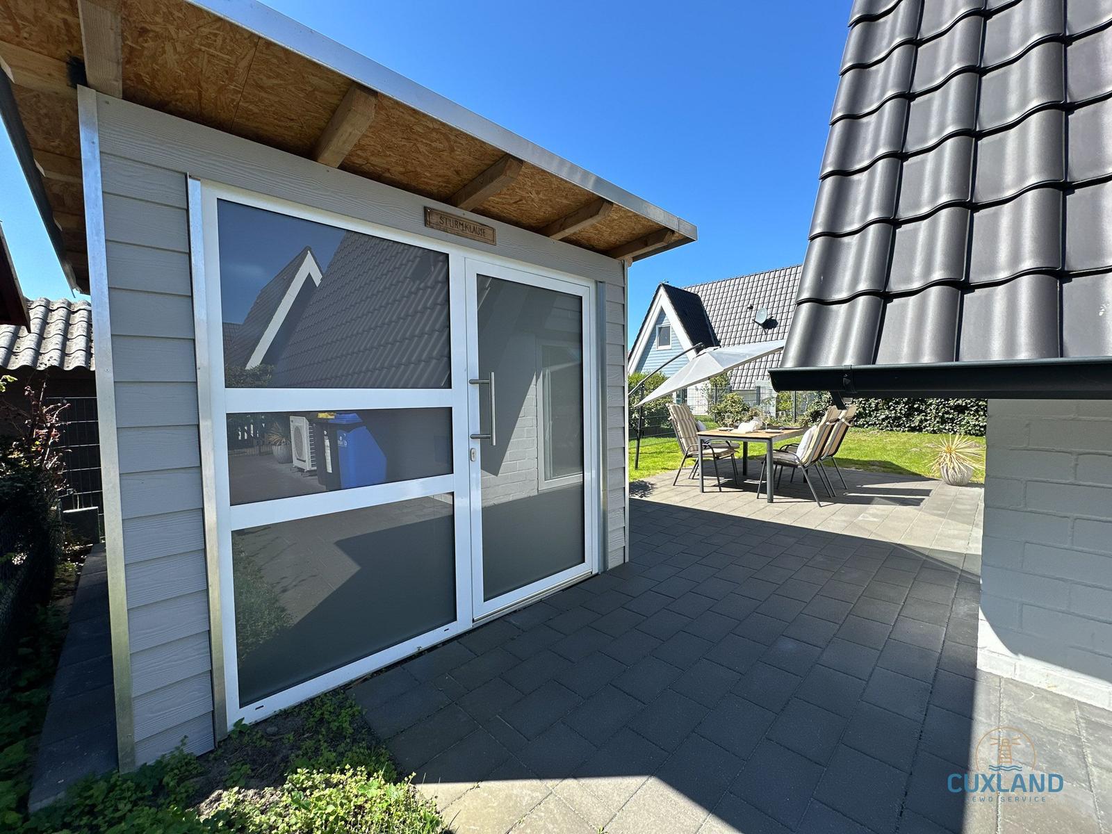 Terrasse mit Sitzgruppe und Schiebetür zur Ferienwohnung.