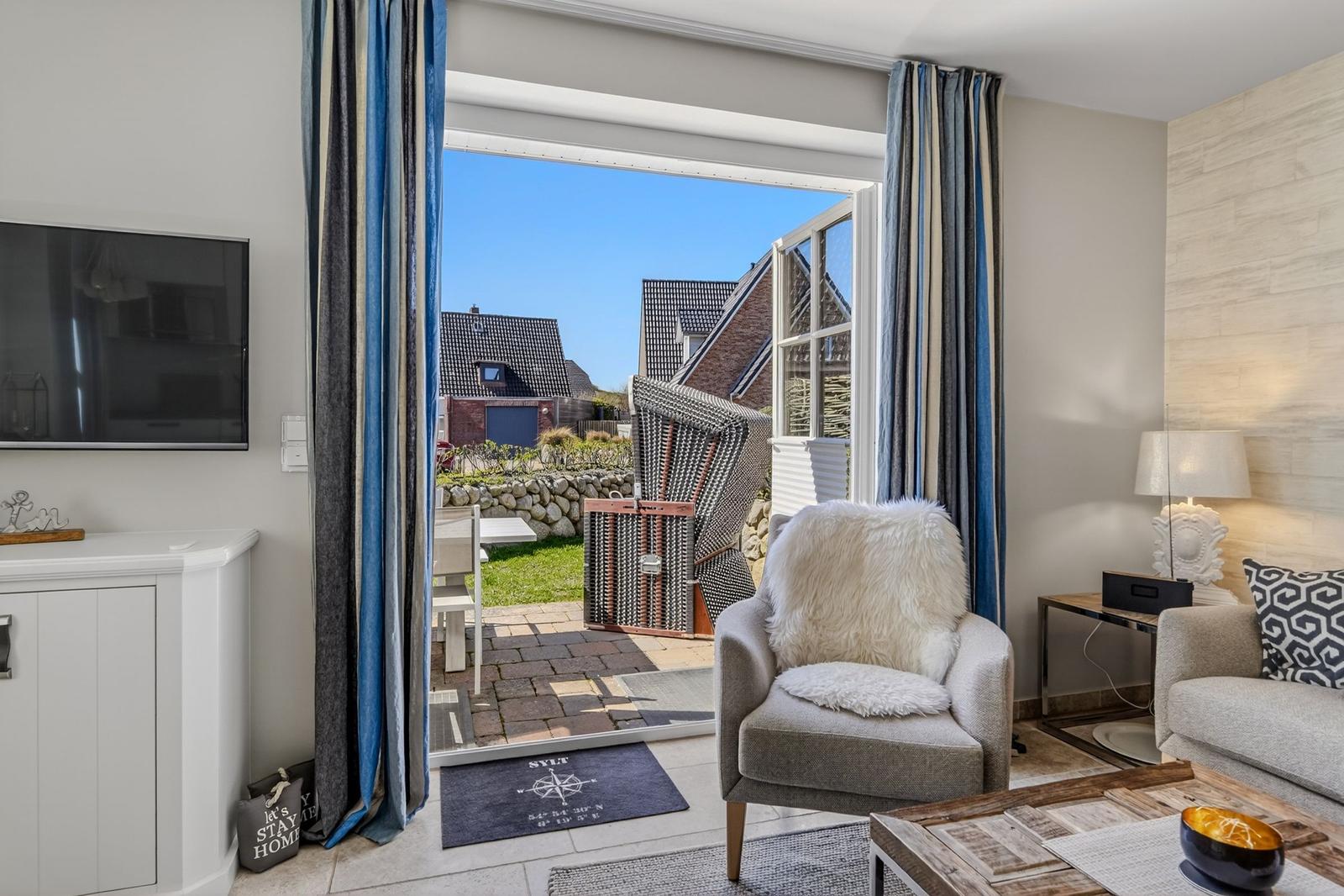 Wohnzimmer mit Sitzgelegenheit und Blick auf den Garten.