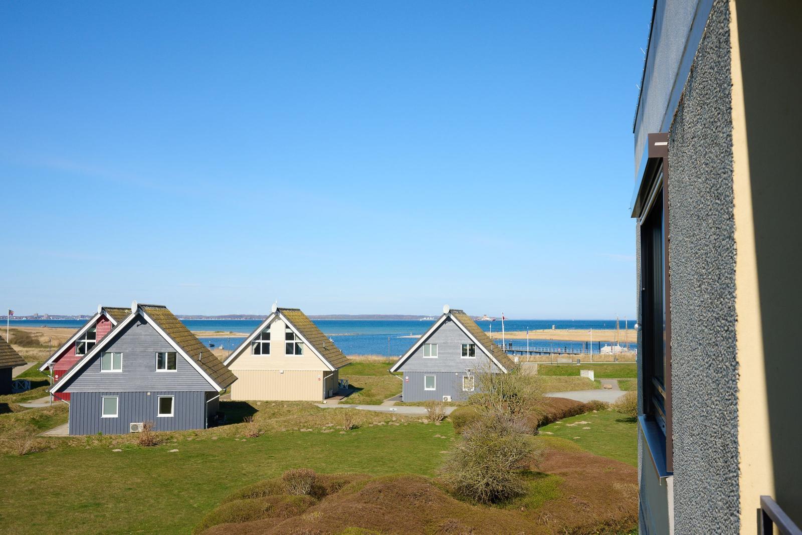 Mein Ferienhaus bietet Blick auf drei Häuser und Meer.