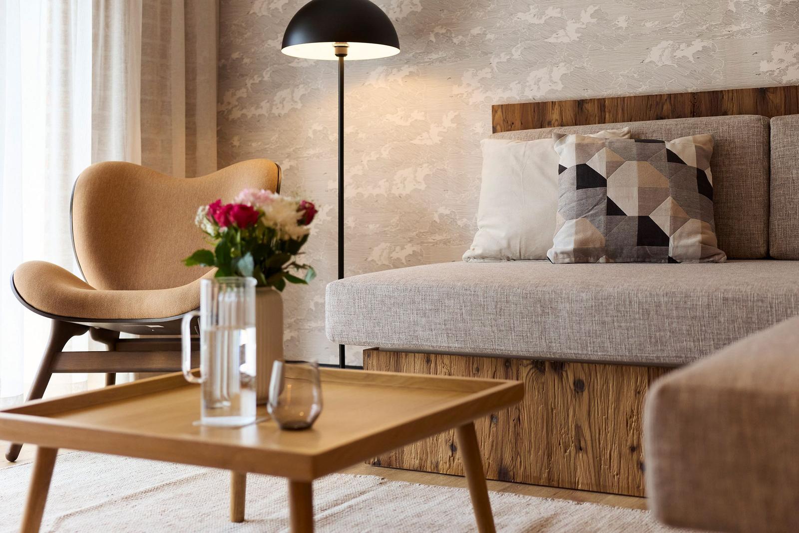Ein Wohnbereich mit Sofa, Sessel, Tisch und Stehlampe.
