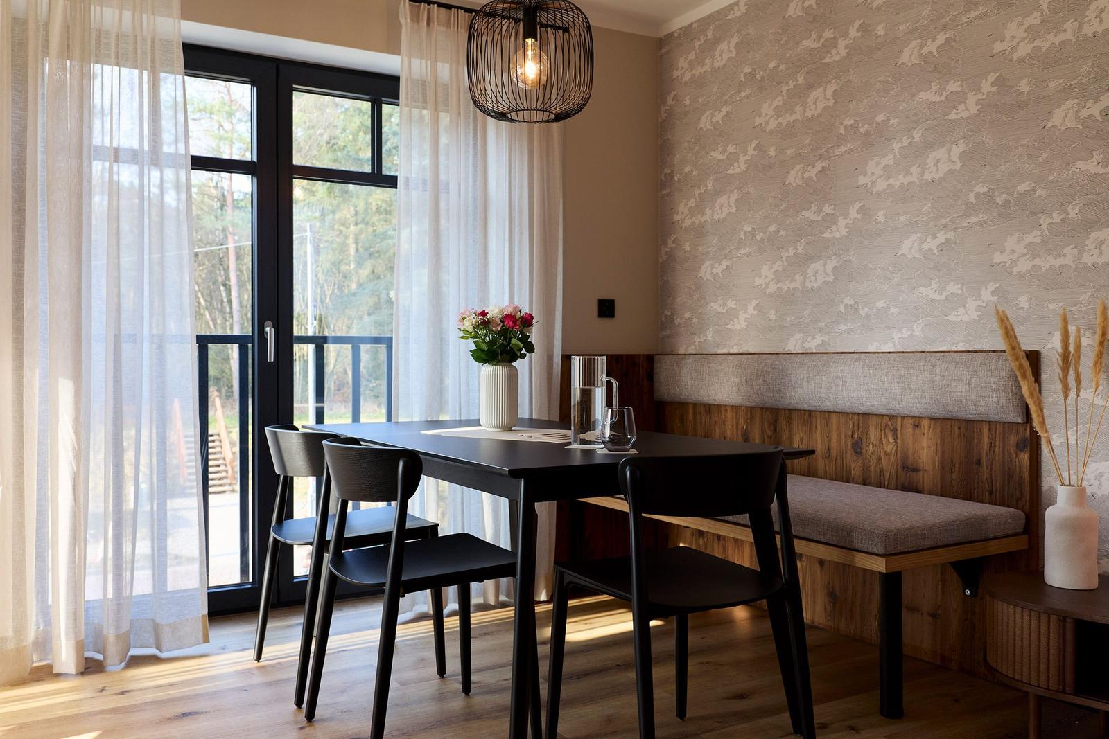 Essbereich mit Tisch, Stühlen und Sitzbank an der Wand.