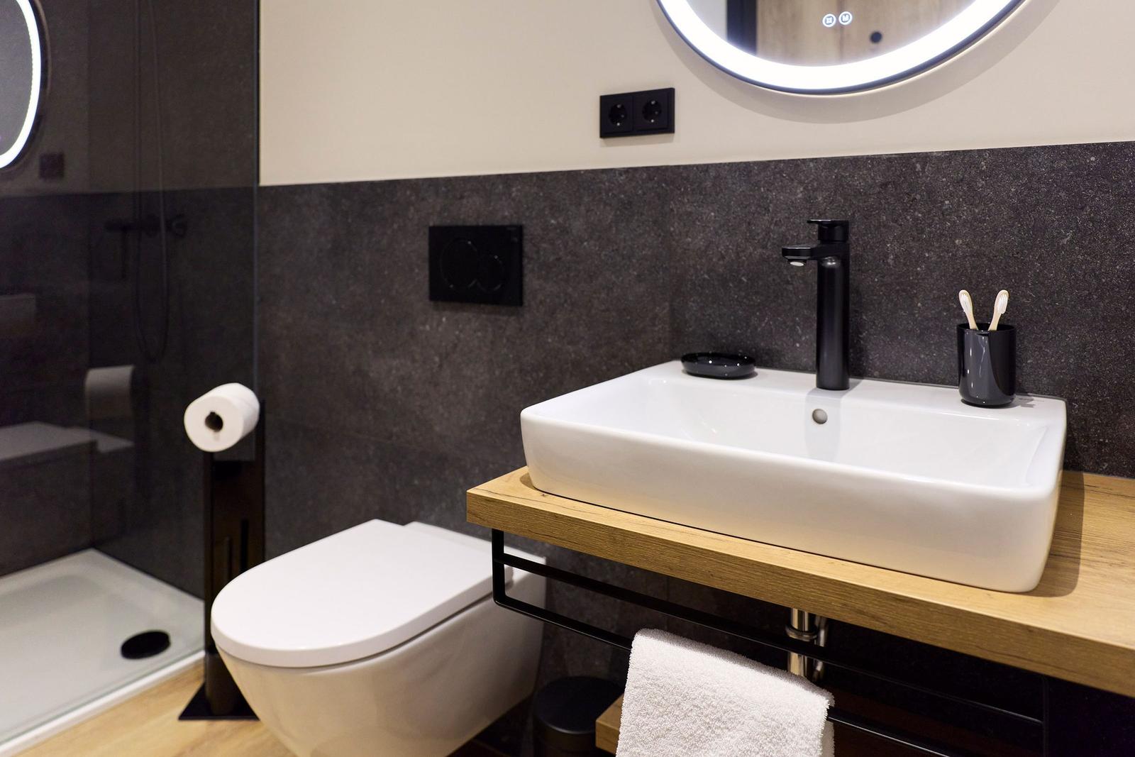 Badezimmer mit Waschbecken, Toilette und Dusche.