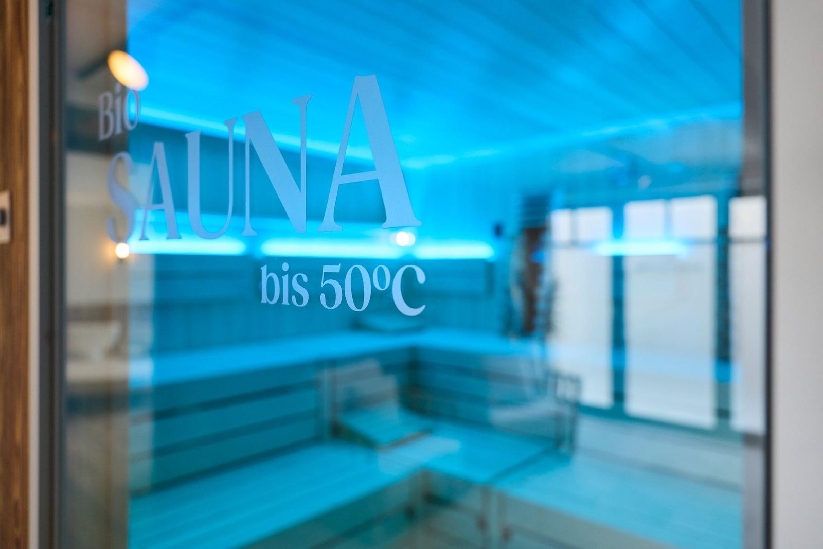 Bio-Sauna bis 50C mit Holzbank und blauer Beleuchtung.