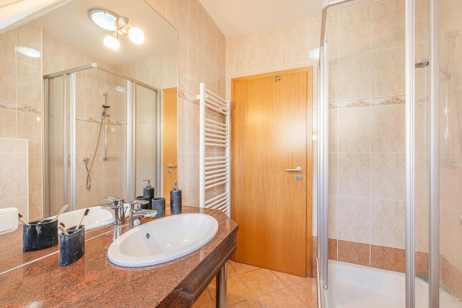 Bad mit Dusche, Waschtisch und Heizkörper