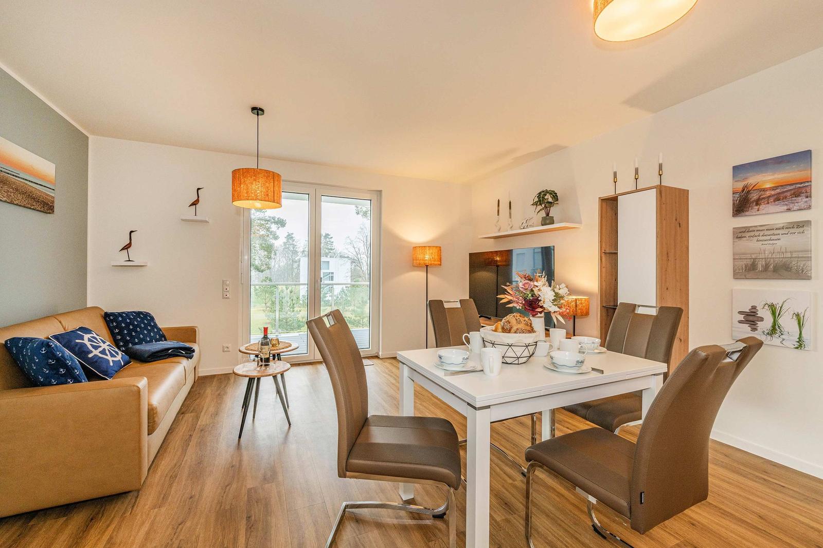 Living and dining area with sofa, dining table, and balcony view.
