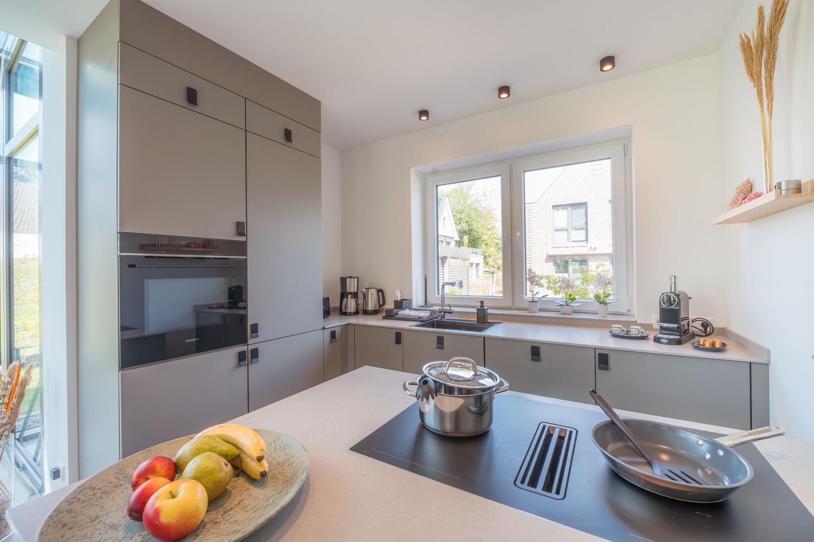 Moderne Küche mit Arbeitsplatte, Fenster und Küchengeräten.