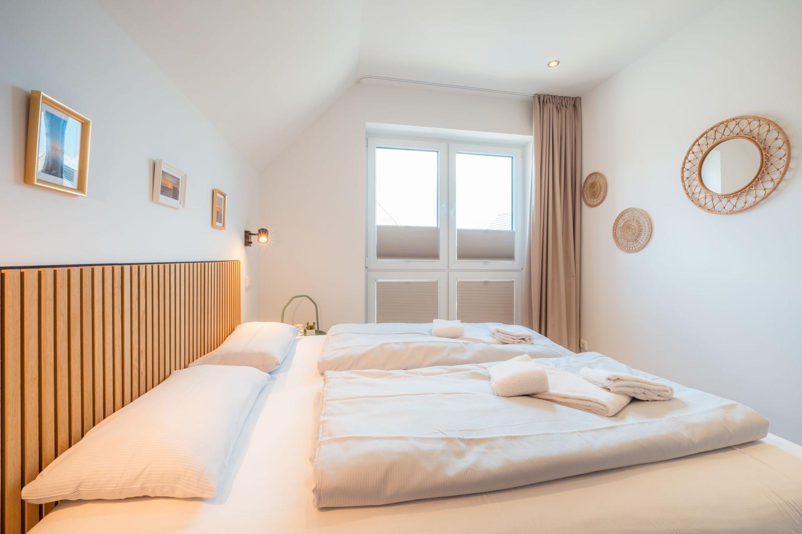 Ein Schlafzimmer mit einem Bett, einem Fenster und Wanddekoration.