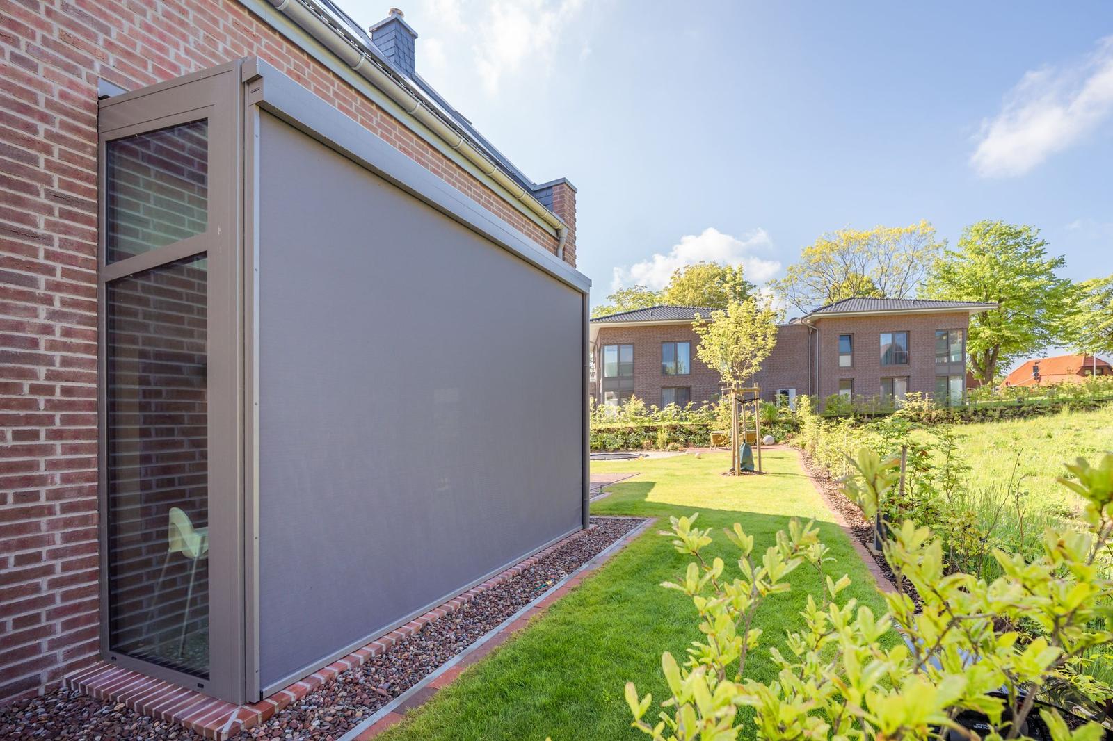 Hinterhof mit Garten, Sonnenschutz und Blick auf Nachbarhaus