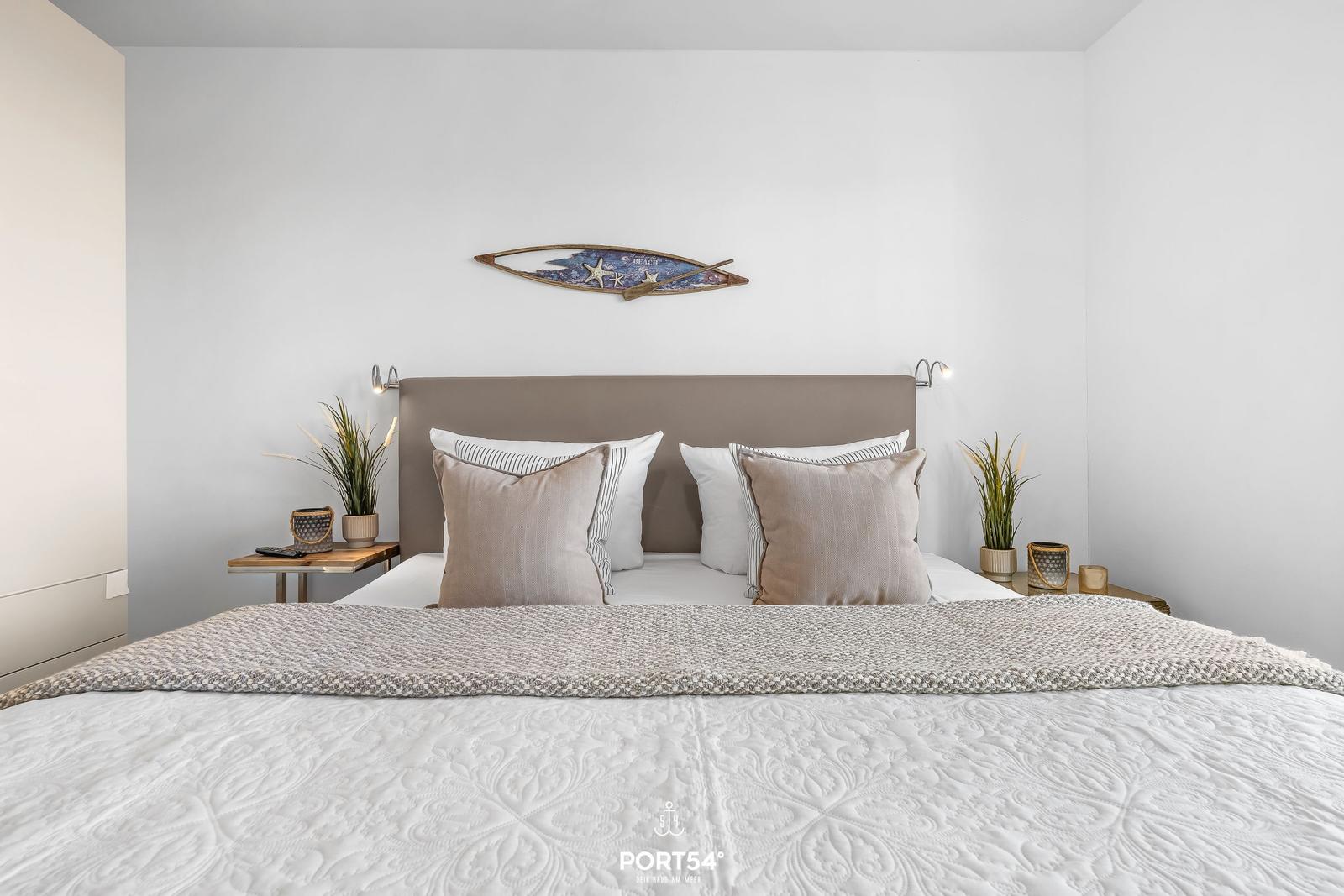 Doppelbett mit Kissen, Nachttische und Wanddekoration