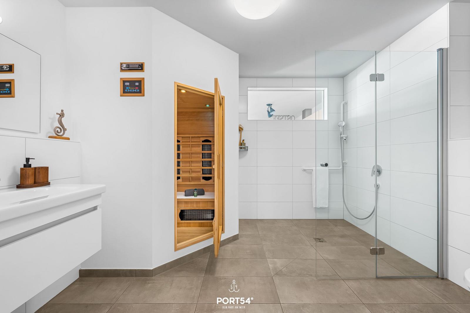 Badezimmer mit Dusche, Sauna und Waschtisch.