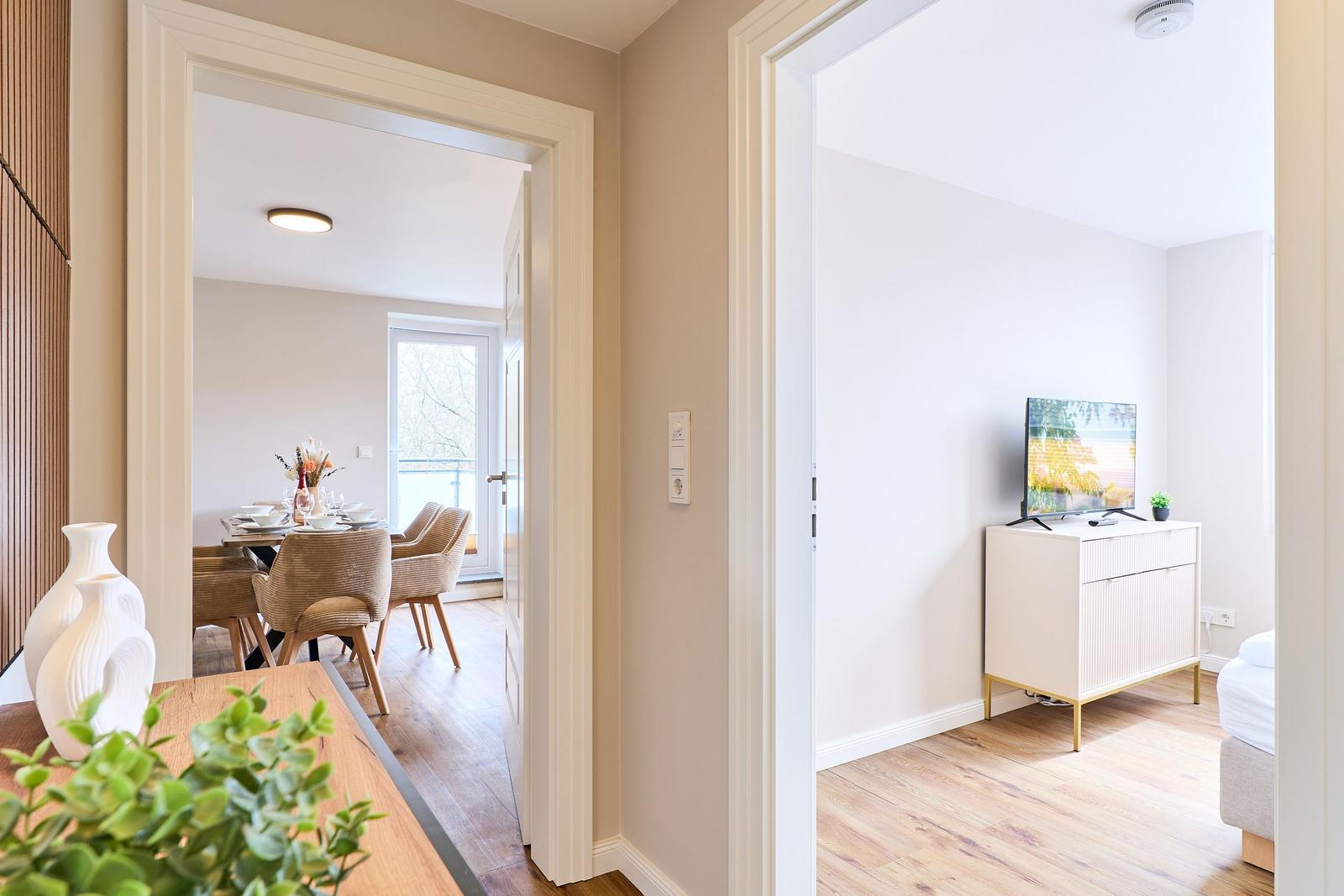 Durchgang zu Esszimmer und Schlafzimmer mit Fernseher und Schrank.