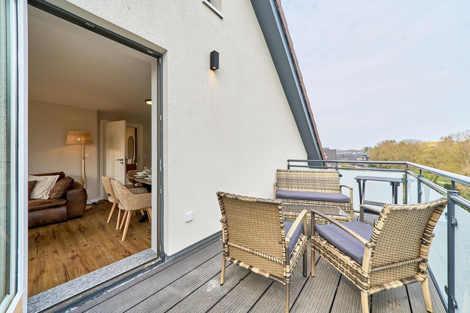 Terrasse mit Sitzgruppe und Blick auf die Umgebung. Durchgang ins Wohn- und Esszimmer.