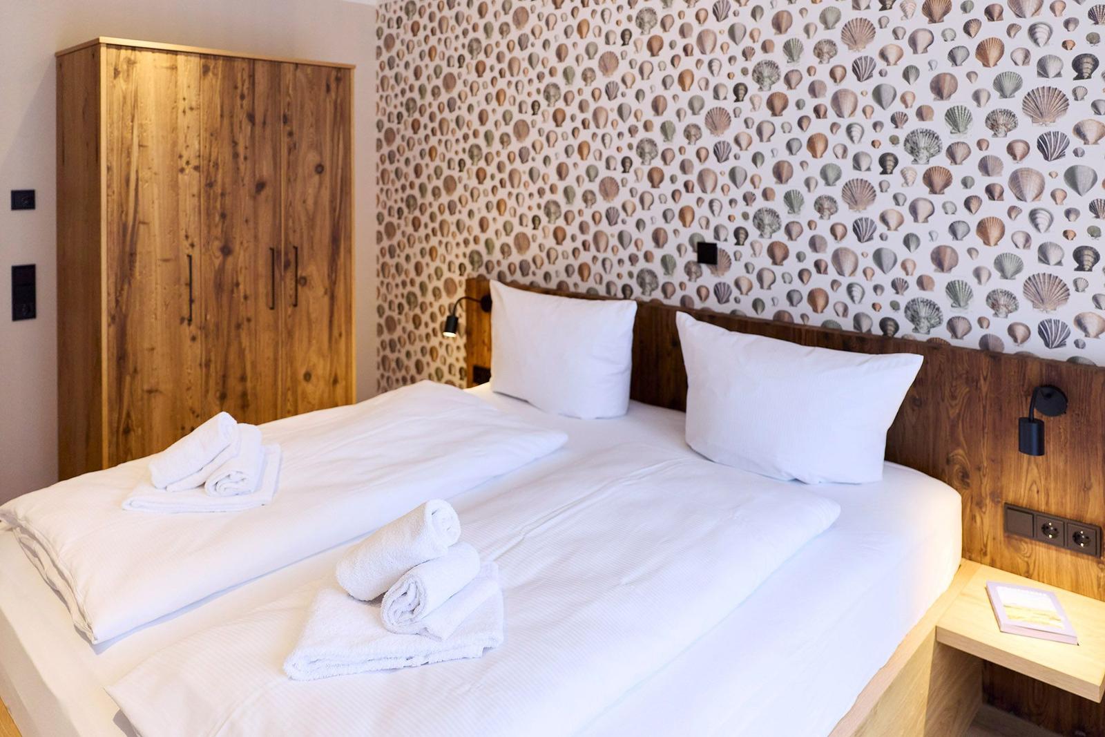 Schlafzimmer mit Bett, Holzschrank und Muschel壁纸.