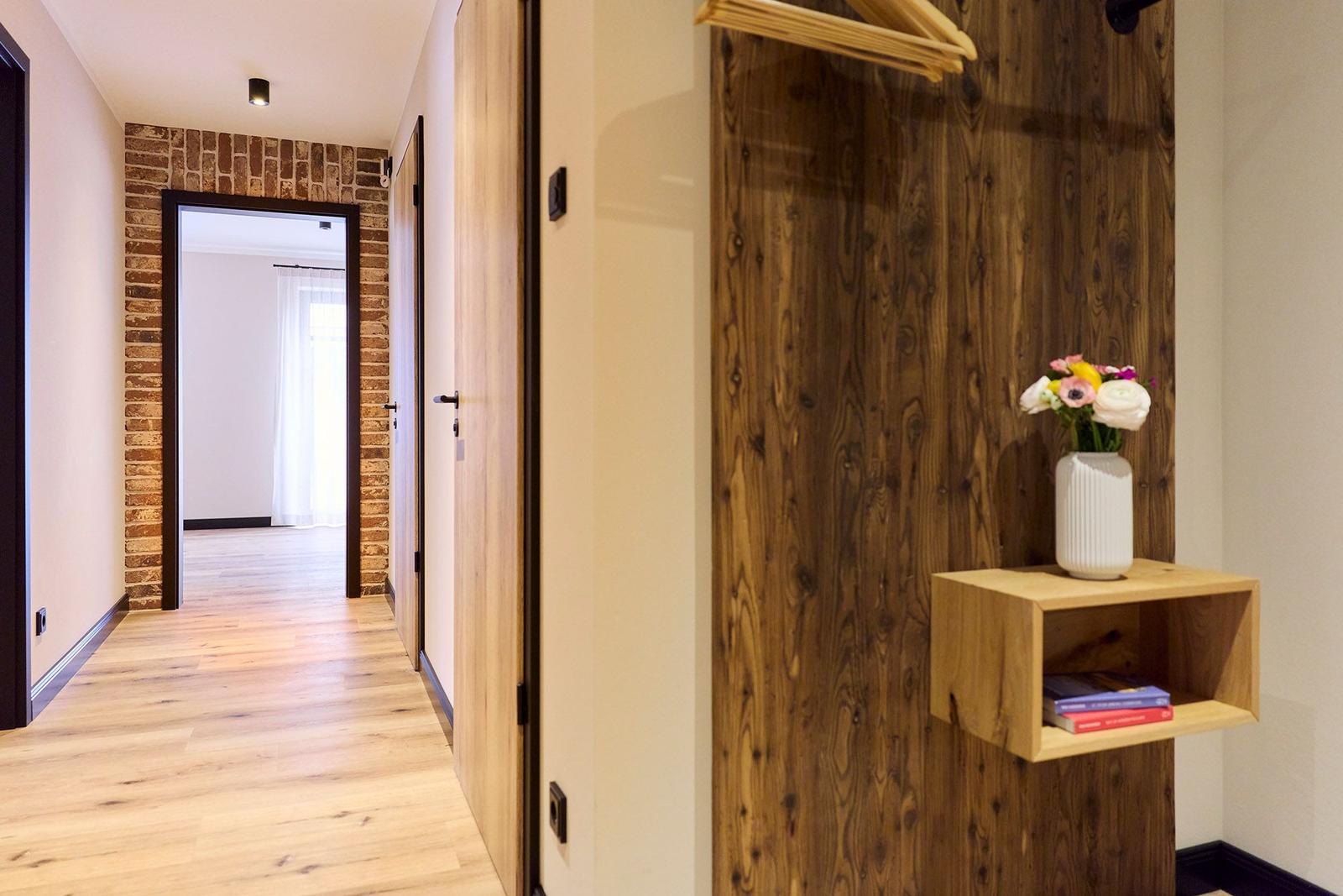 Flur mit Holzboden, Holzwand und Vase mit Blumen