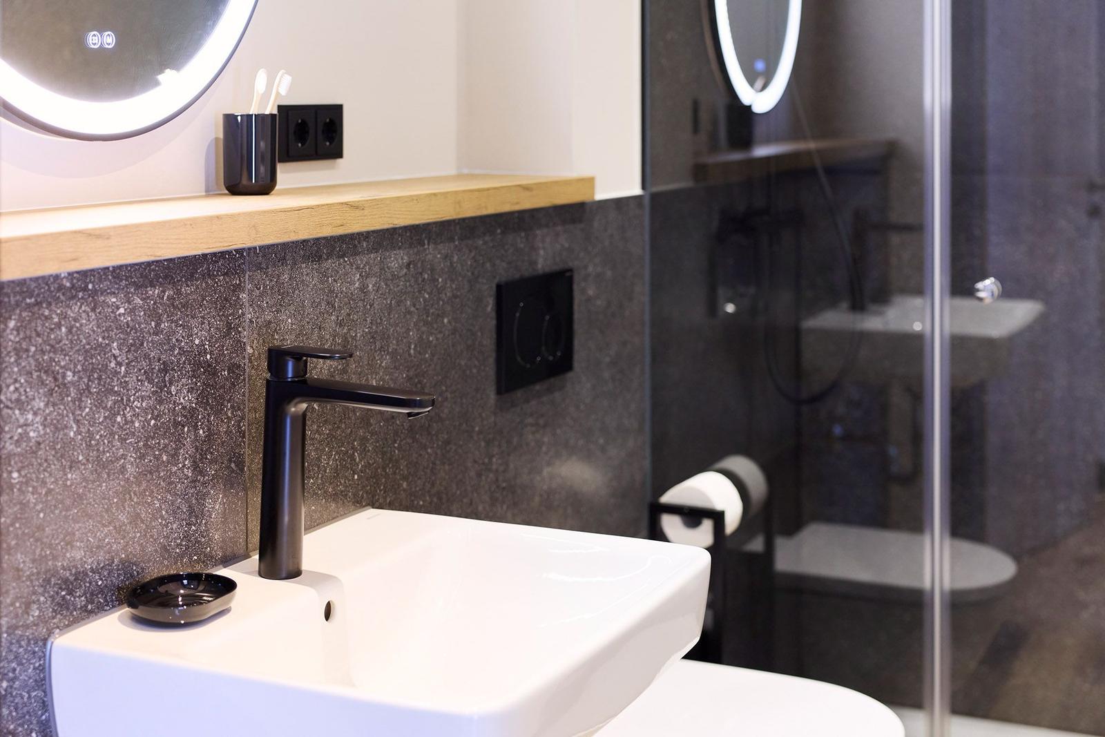 Bad mit Waschbecken, Spiegel und Dusche