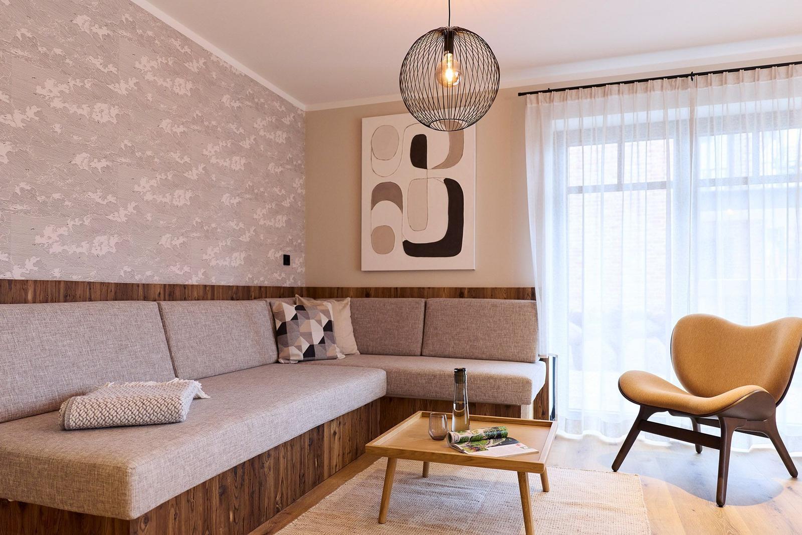 Ein Wohnzimmer mit Sofa, Stuhl und Tisch. An der Wand hängt ein Bild.