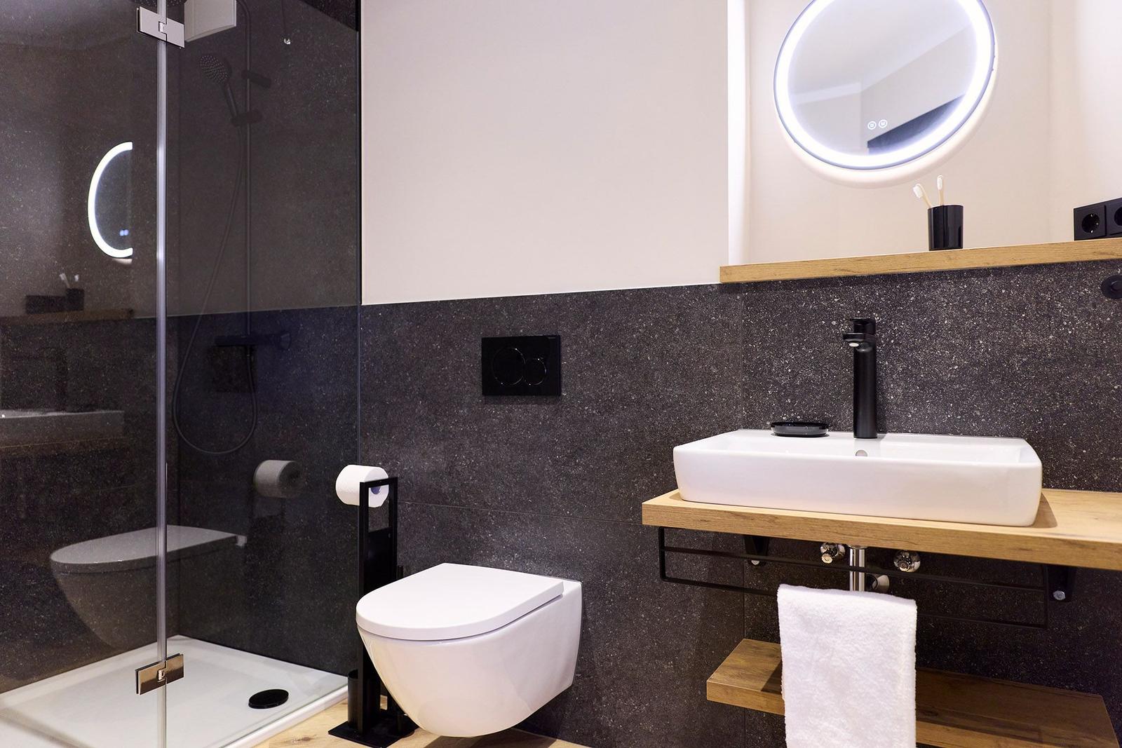 Moderne Badezimmer mit Dusche, Toilette und Waschbecken.