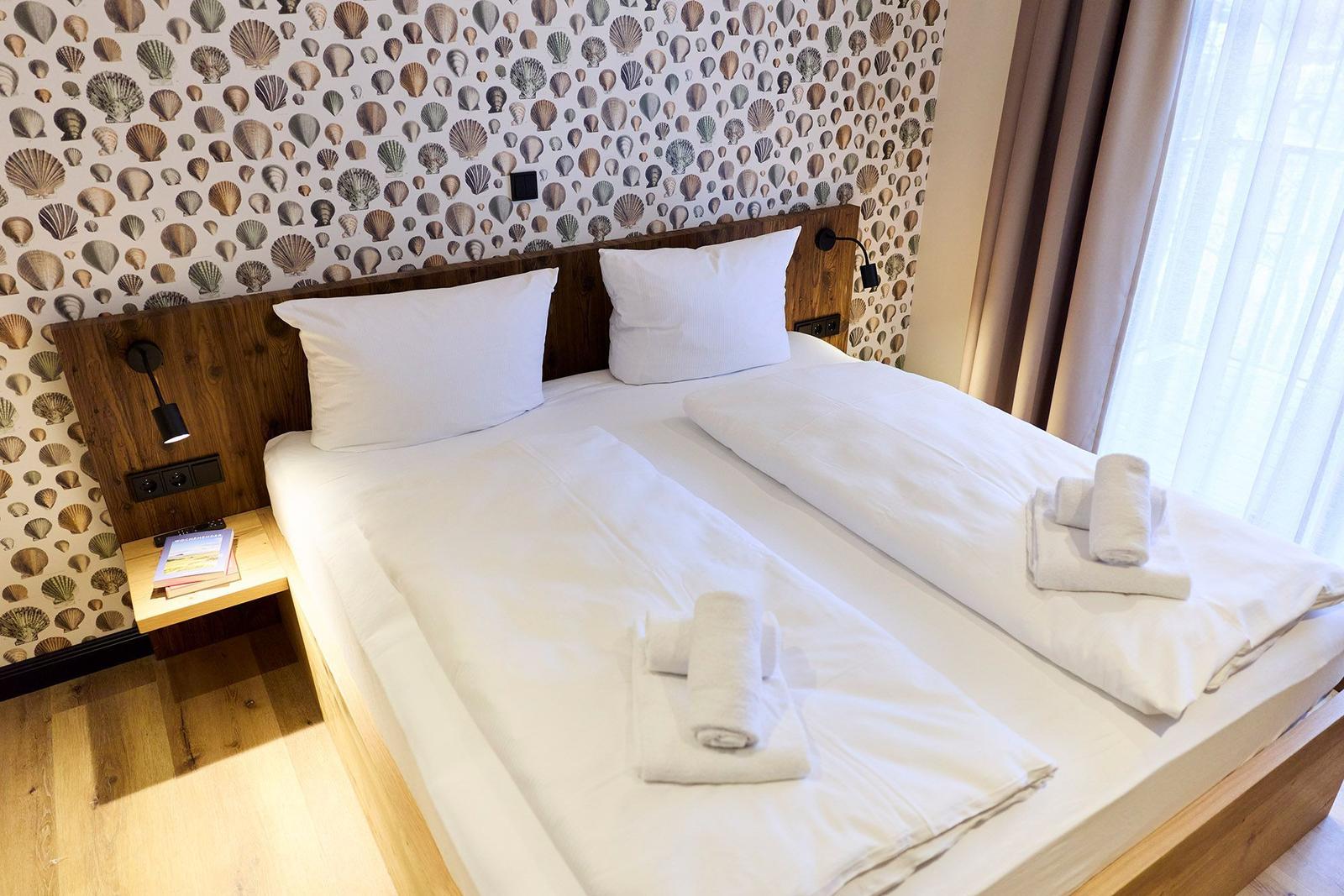 Schlafzimmer mit Bett, weißen Laken und Muschel壁纸.