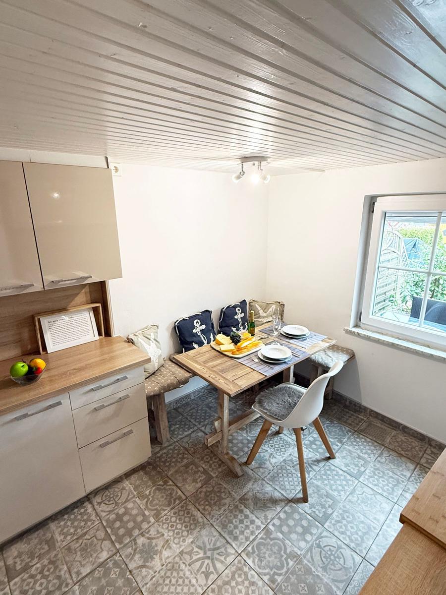 Küche mit Esstisch, Fenster und Holzdecke