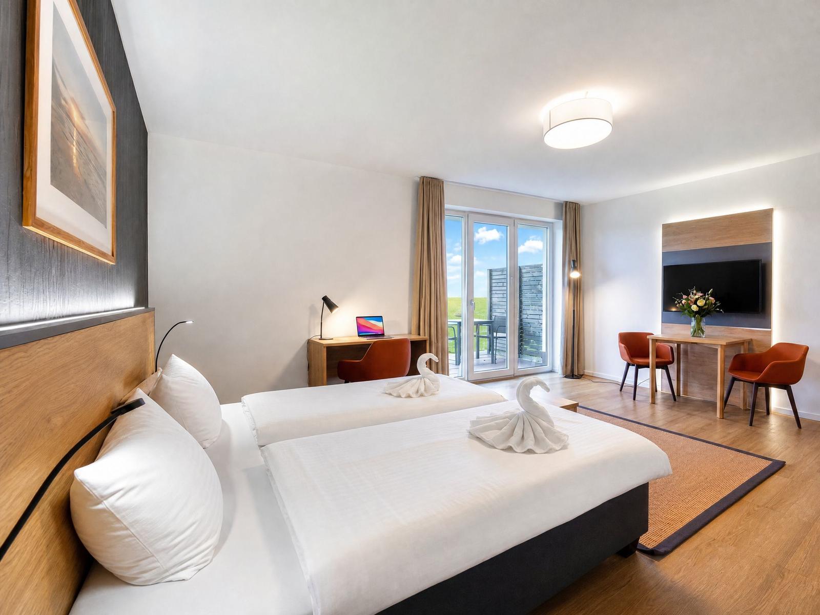 Zwei Betten mit weißen Laken, Schlafzimmer mit Schreibtisch, TV und Balkon.