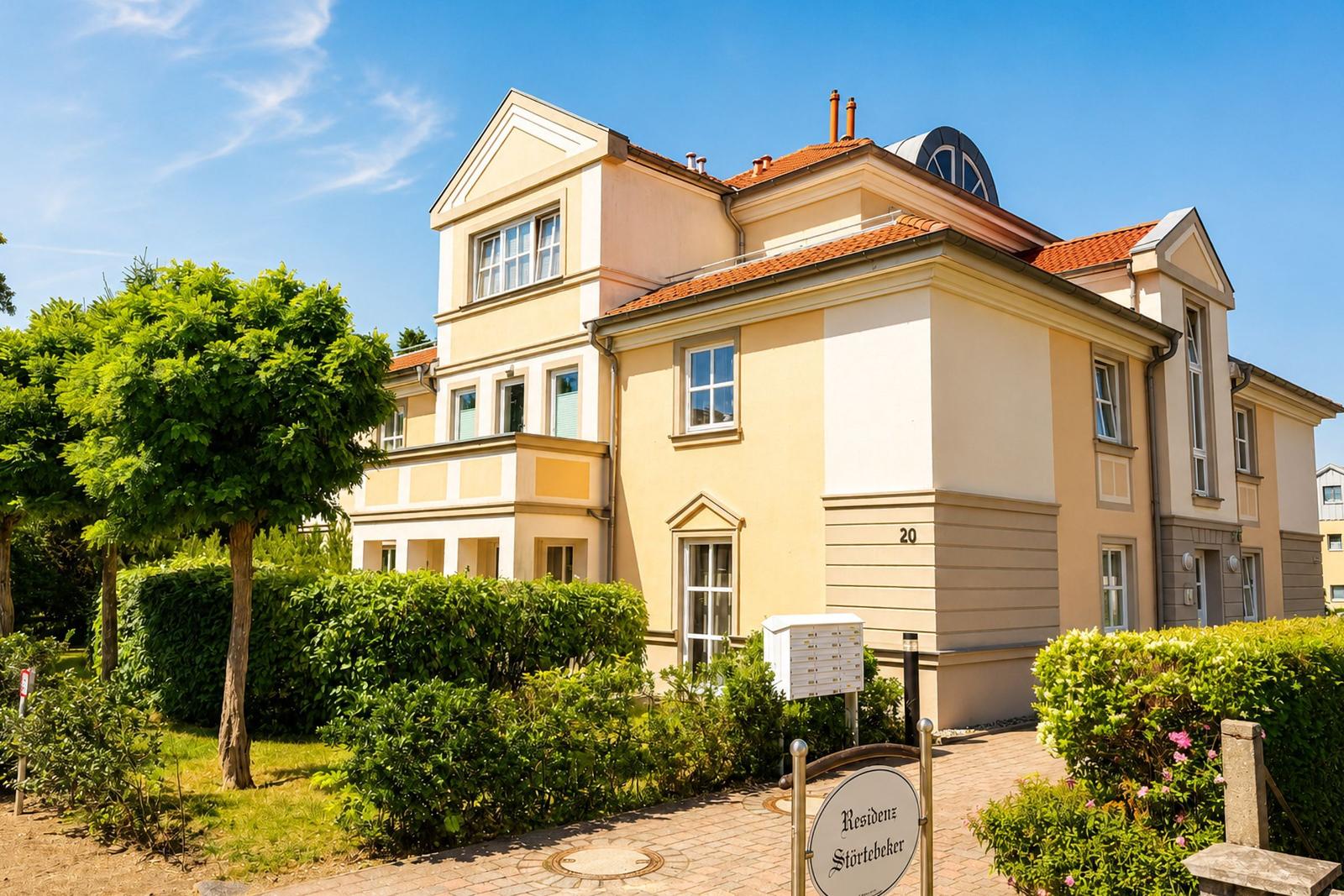 Residenz Störtebeker, ein mehrstöckiges Gebäude mit Terrakottadach und grüner Umgebung.