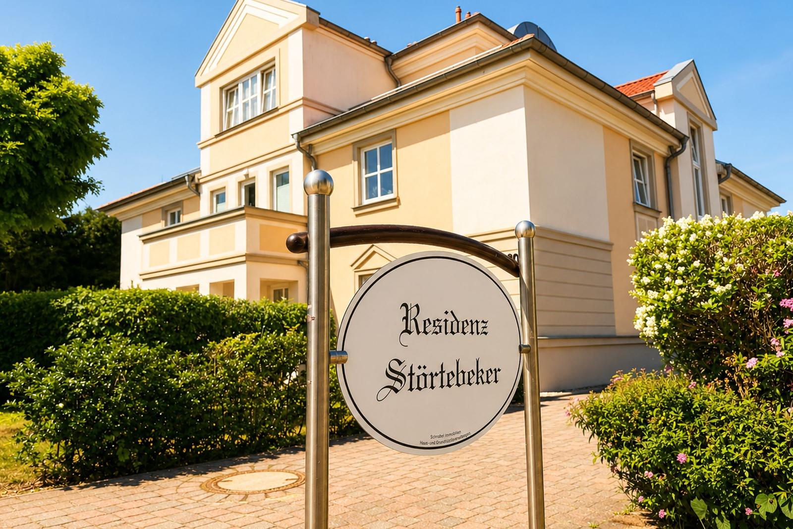 Residenz Störtebeker mit gepflegtem Garten und Schild an Eingang.