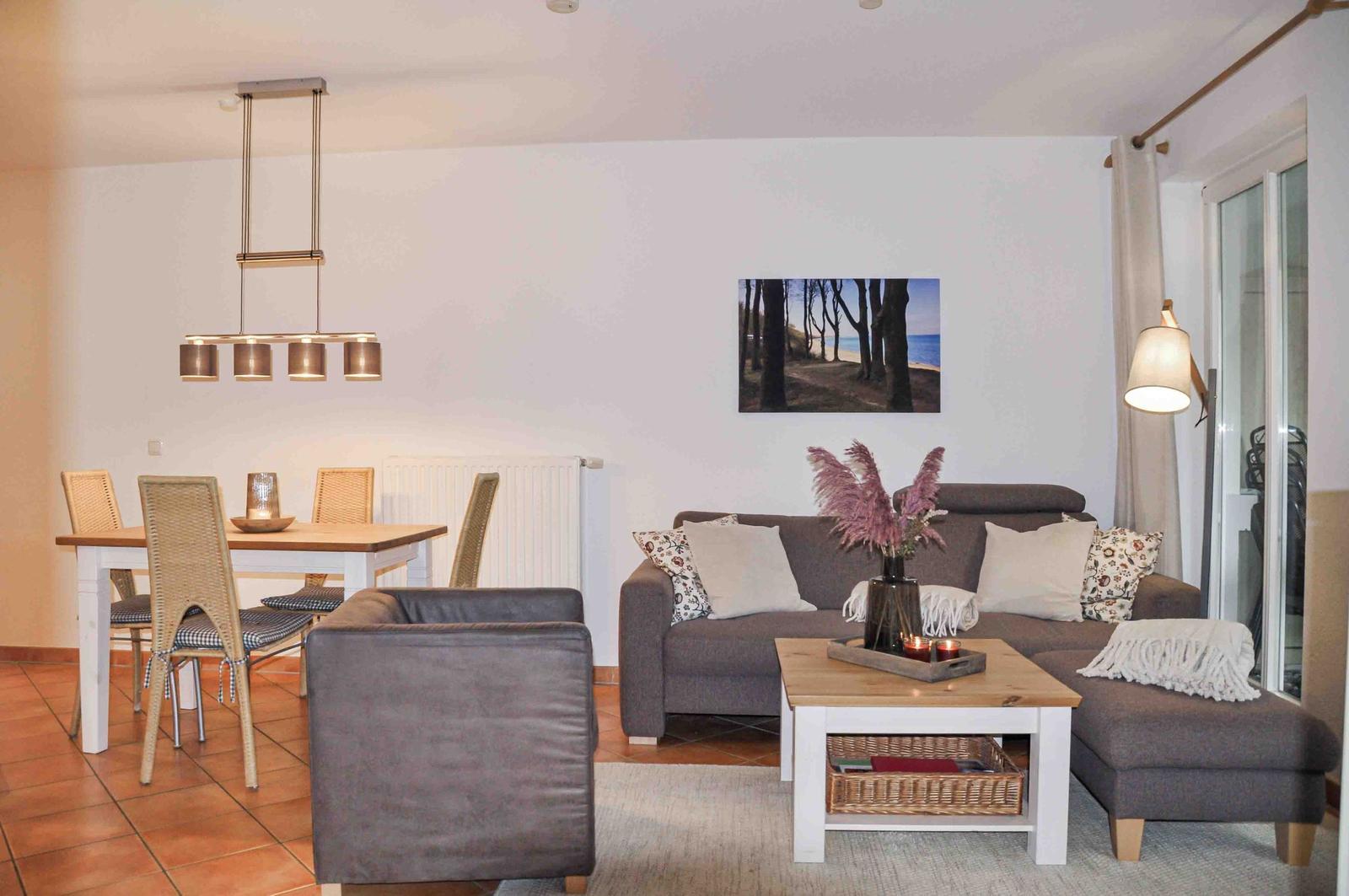 Wohn- und Essbereich mit Sofa, Tisch und Stühlen sowie Wandbild.