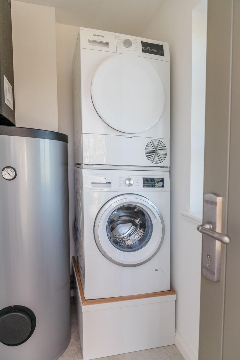 Dryer and washing machine in a room with water heater.