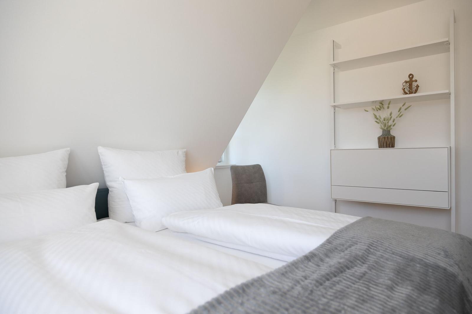 Schlafzimmer mit Bett, Schrank und Regal an der Wand.