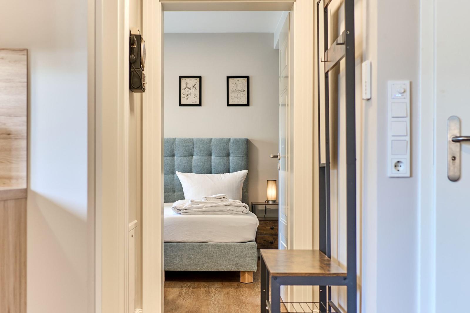 Schlafzimmer mit Bett, Nachttisch und Wandbildern