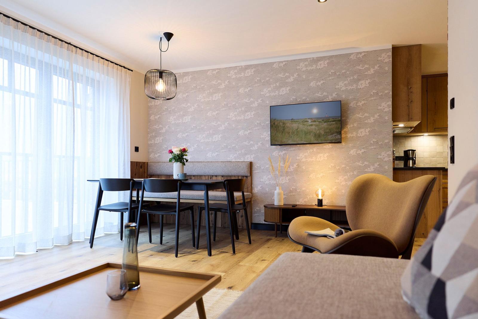 Wohn- und Essbereich mit Holzboden, TV und Sitzgelegenheiten.