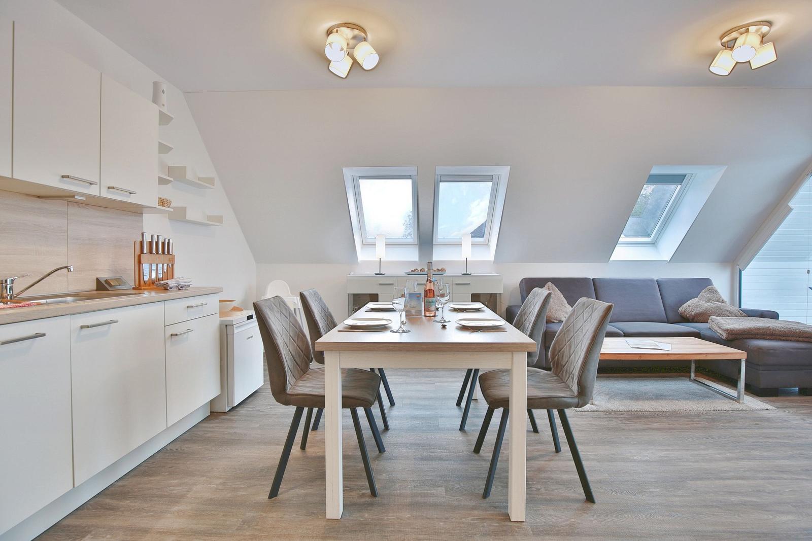 Wohnküche mit Essbereich, Sofa und Dachfenstern.