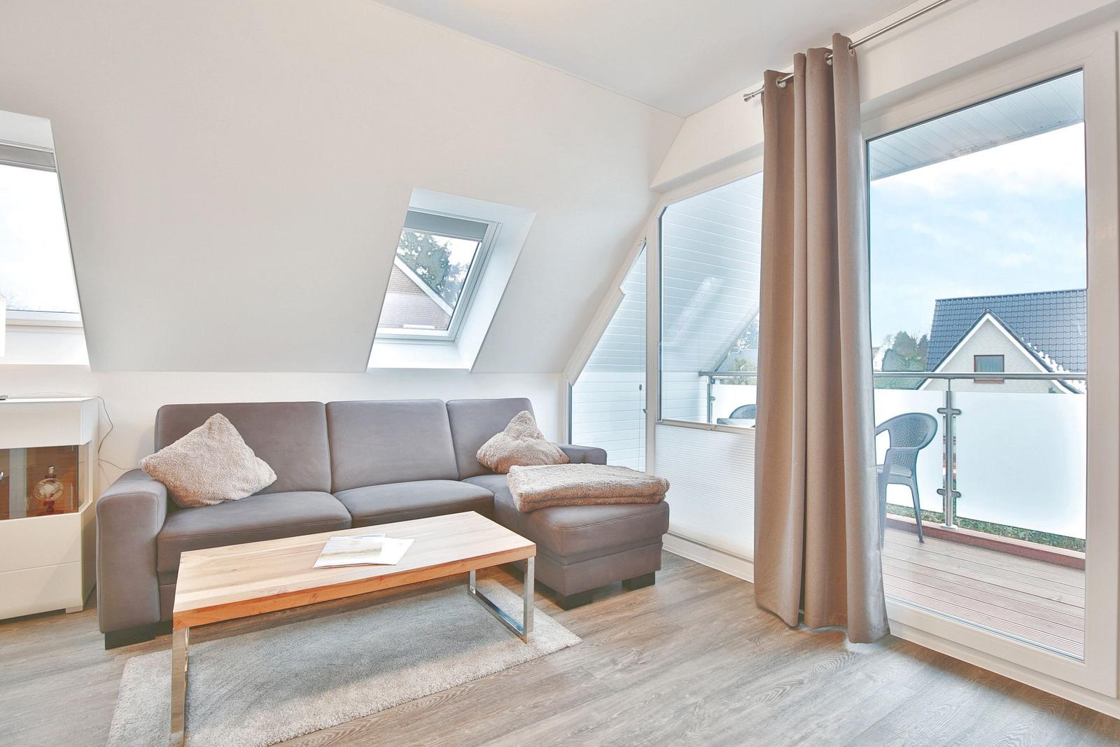 Wohnzimmer mit Sofa, Couchtisch und Balkonansicht.