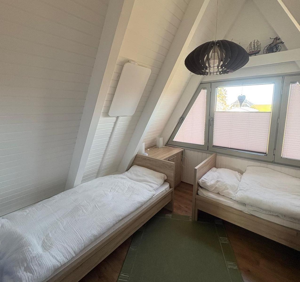 Zimmer mit zwei Betten, Fenster und Deckenleuchte