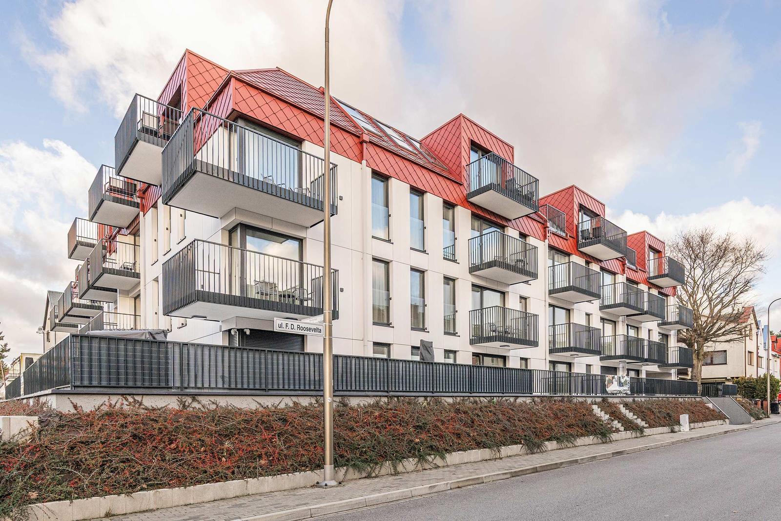 Moderne Wohnanlage mit roten Dächern und Balkonen an der Rooseveltstraße.
