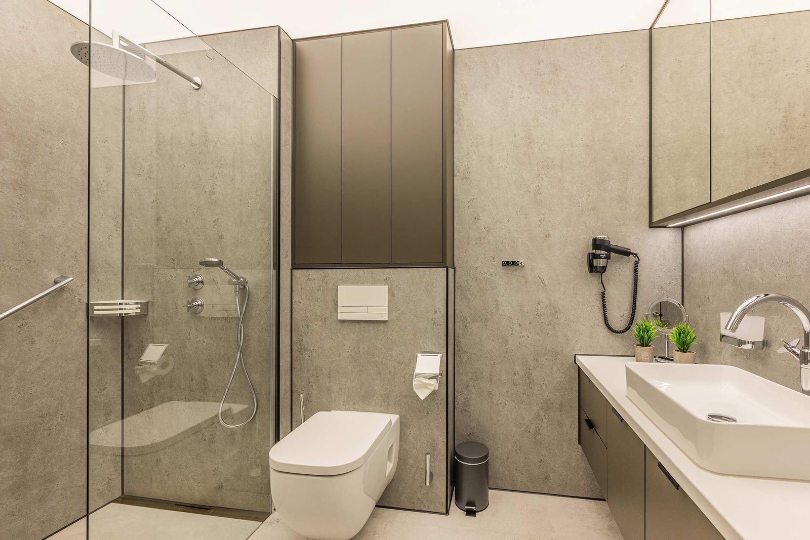 Moderne Badezimmer mit Dusche, Toilette und Waschbecken.