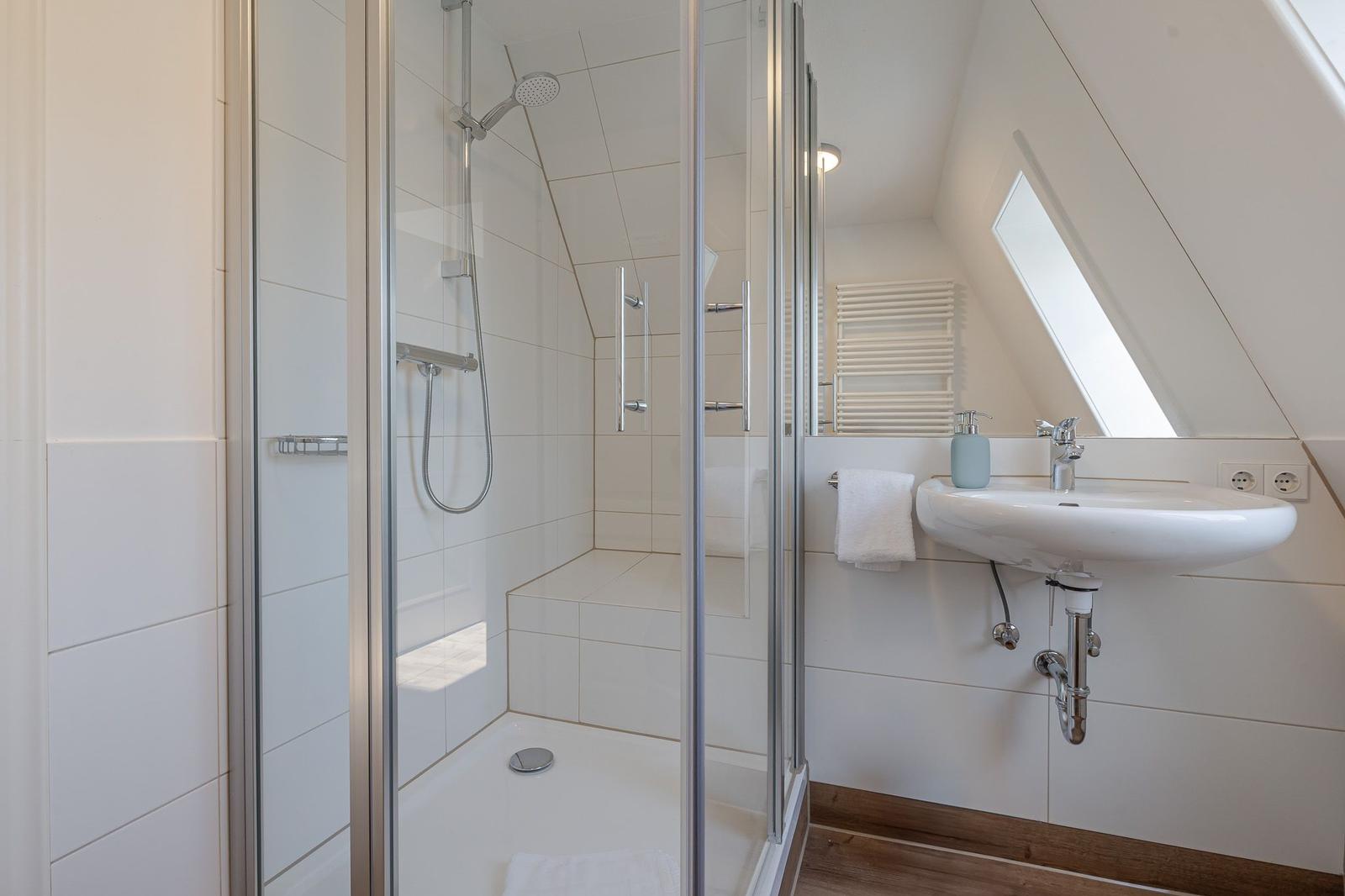 Duschbereich mit Dusche und Waschbecken unter Dachschrägen