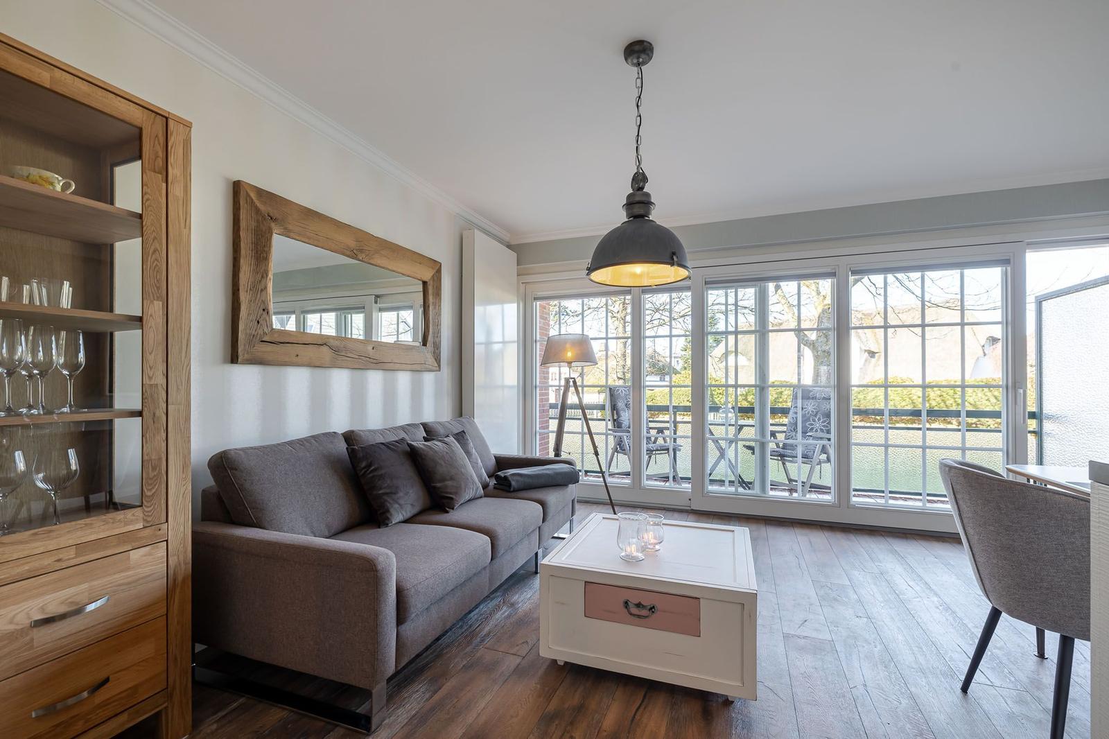 Wohnzimmer mit Sofa, Couchtisch und Blick auf Balkon.