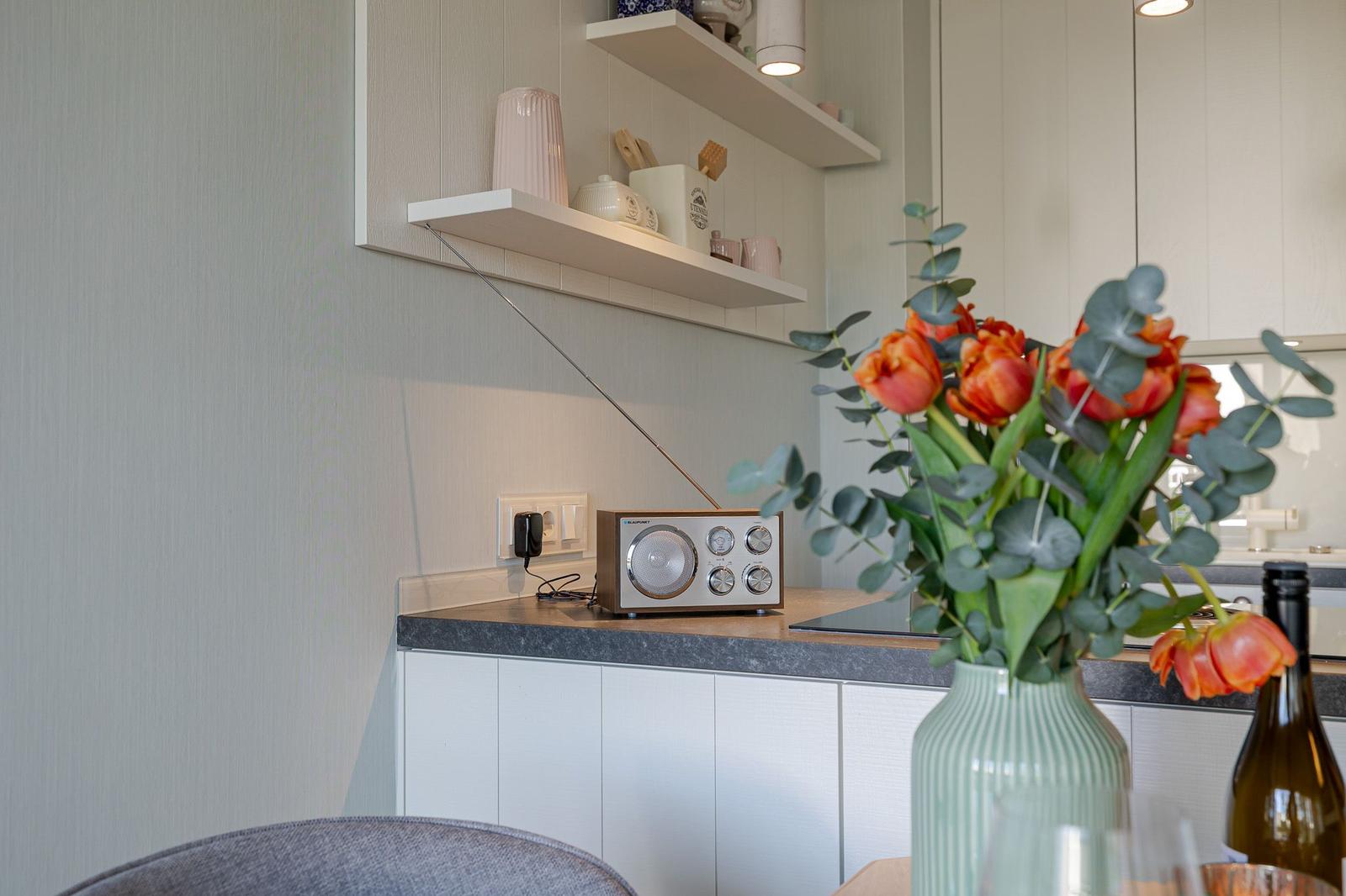 Küchenbereich mit Radio, Blumen und Arbeitsfläche