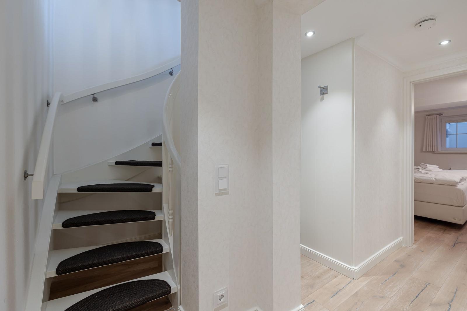 Höhenunterschied mit Treppe und Schlafzimmer im Hintergrund.
