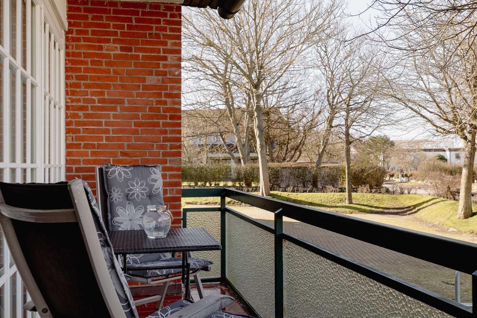 Terrasse mit Stuhl und Tisch, Blick auf Bäume und Rasen
