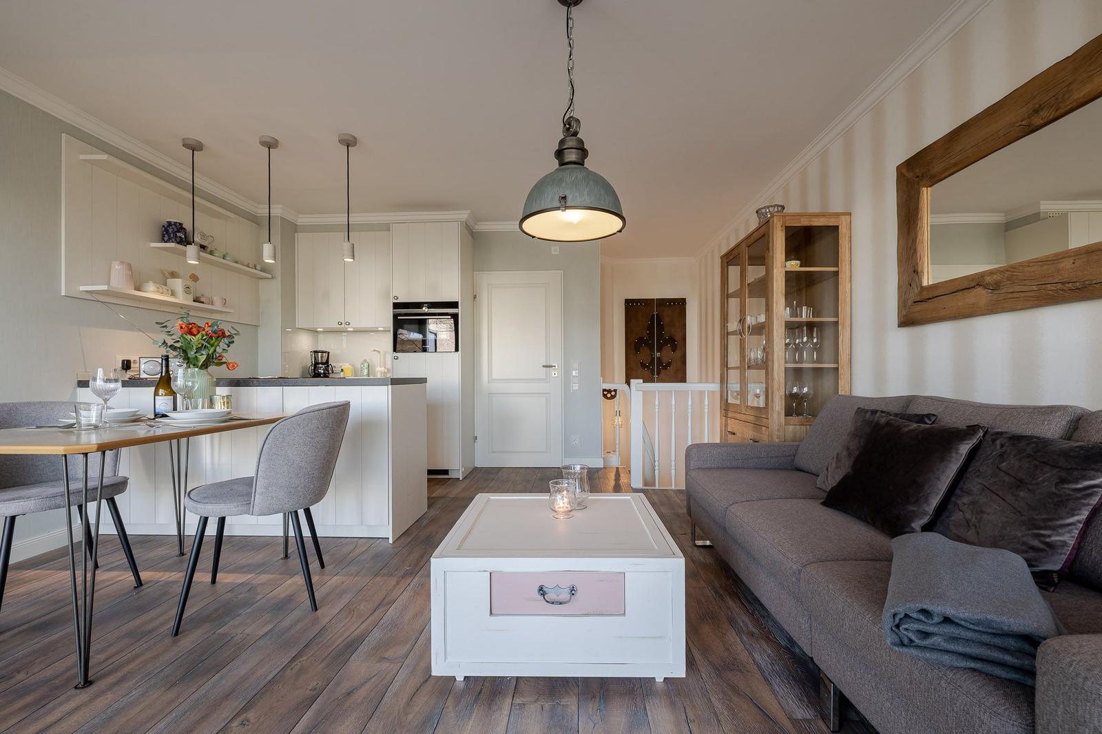 Wohn- und Essbereich mit Kücheninsel, Sofa und Holzboden.