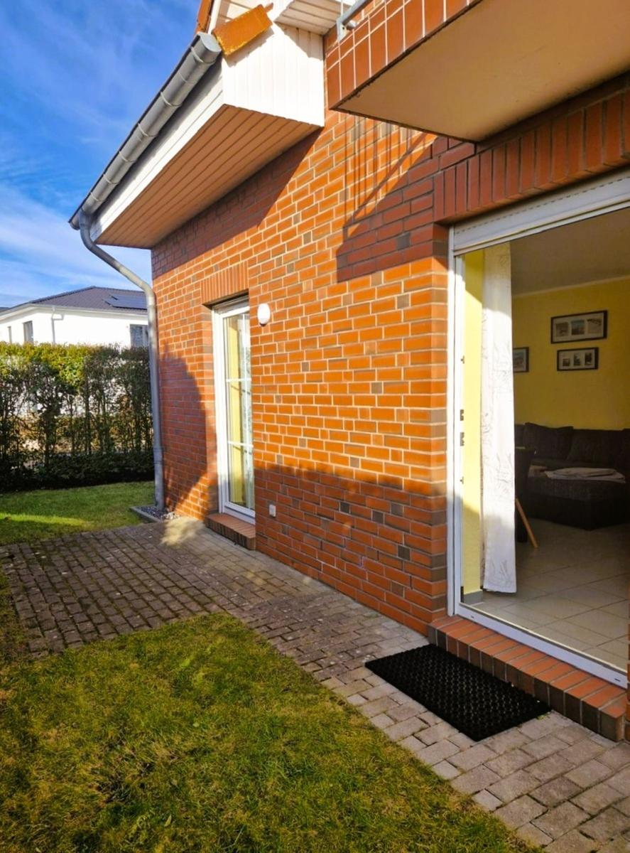 Haus mit rotem Backsteinfassade, Terrasse und Blick ins Innere.