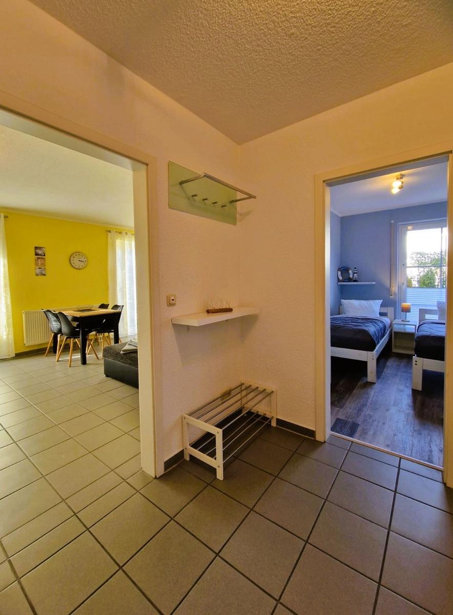 Flur mit Blick in Essbereich und Schlafzimmer mit zwei Betten.
